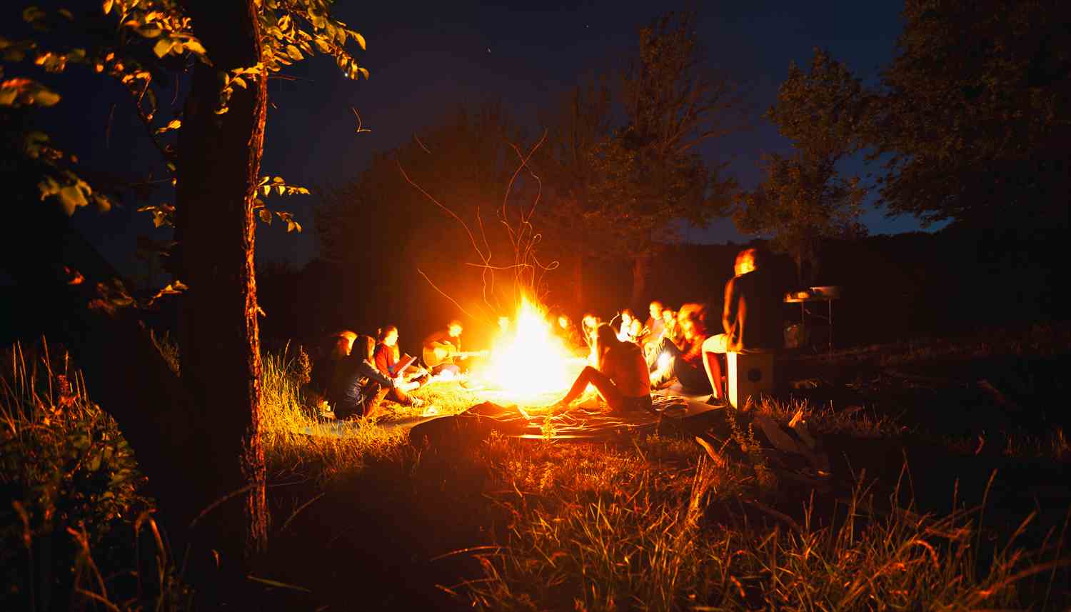 Scouts gathered around a campfire at night