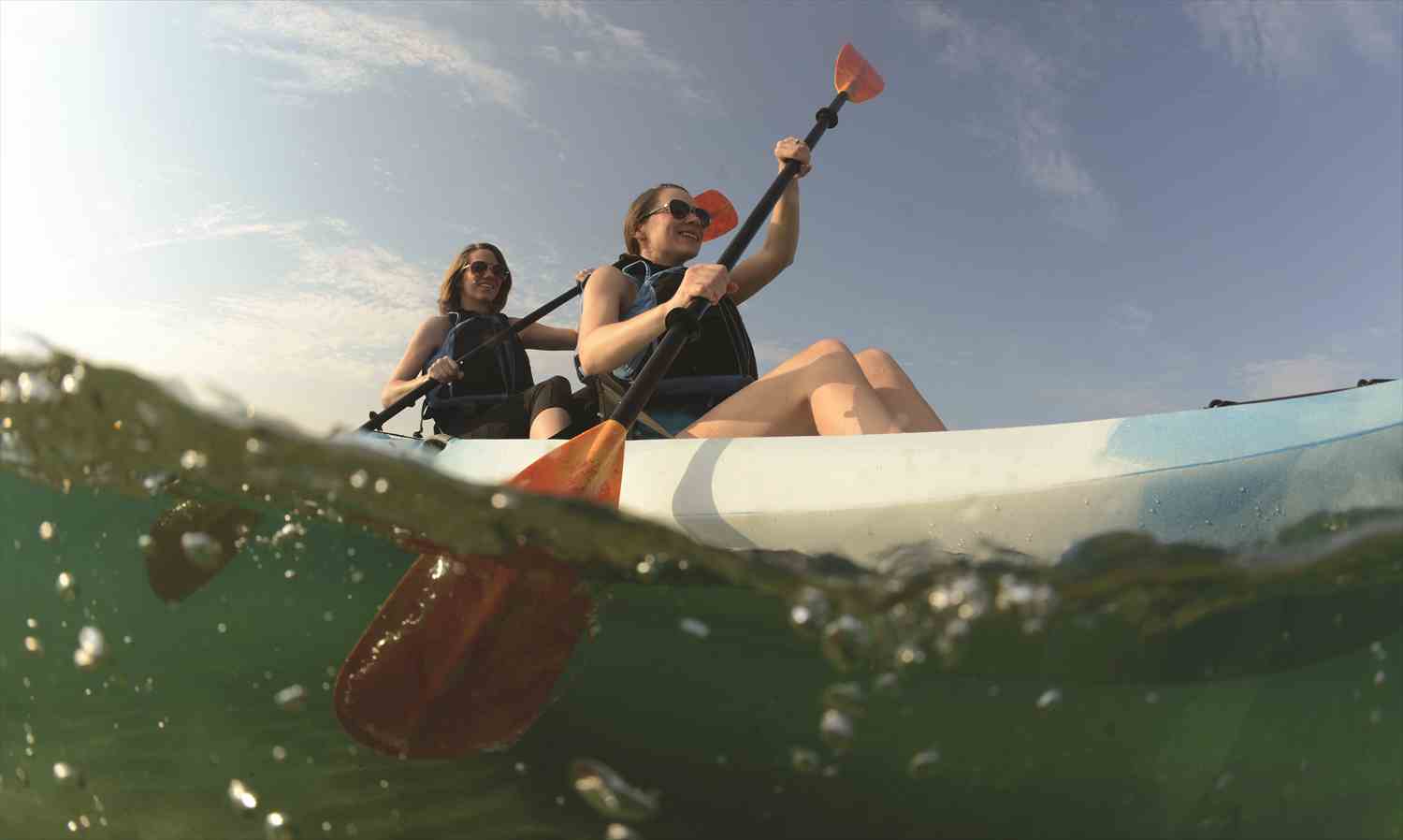 A group of kayakers paddling together on calm water