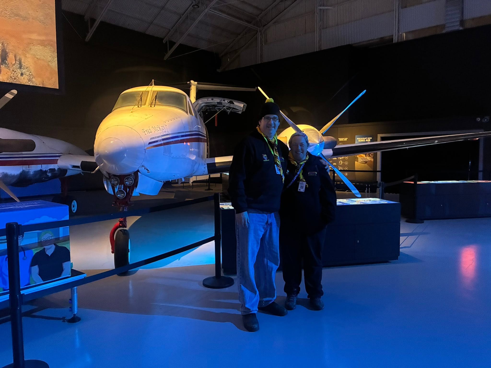 Two Bundoora Scout leaders standing in front of a Royal Flying Doctor Service aircraft at the Broken Hill museum
