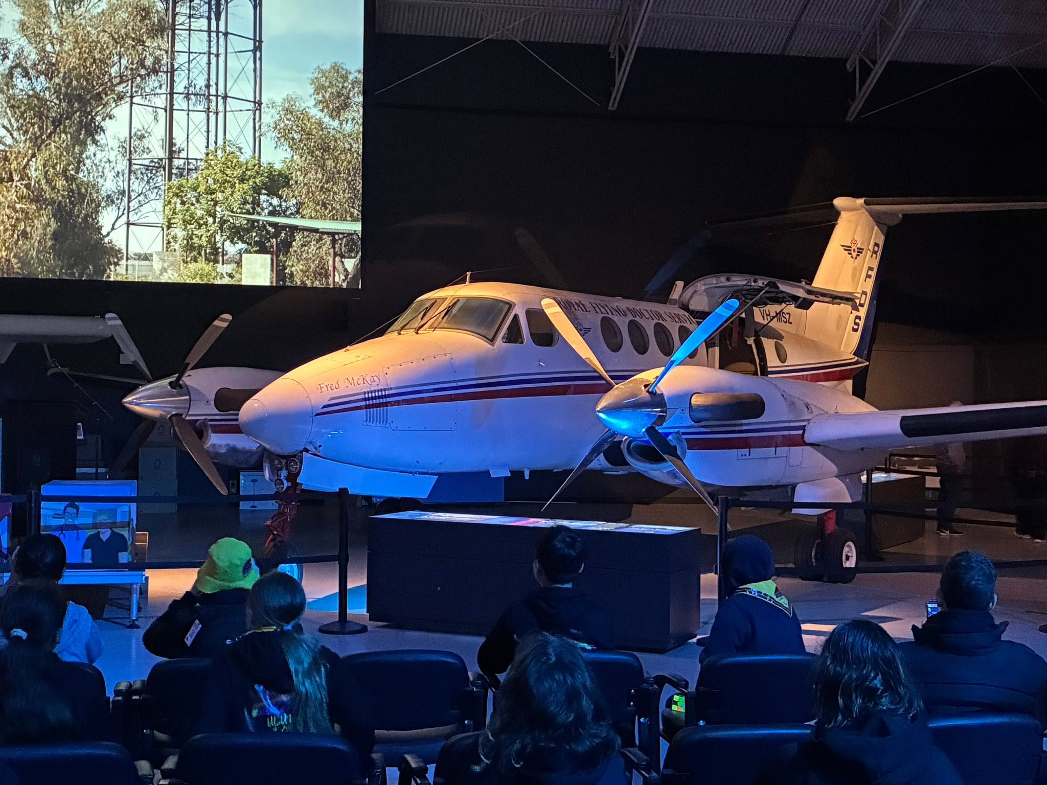 Uluru expedition group watching a Royal Flying Doctor Service aircraft display at the Broken Hill museum