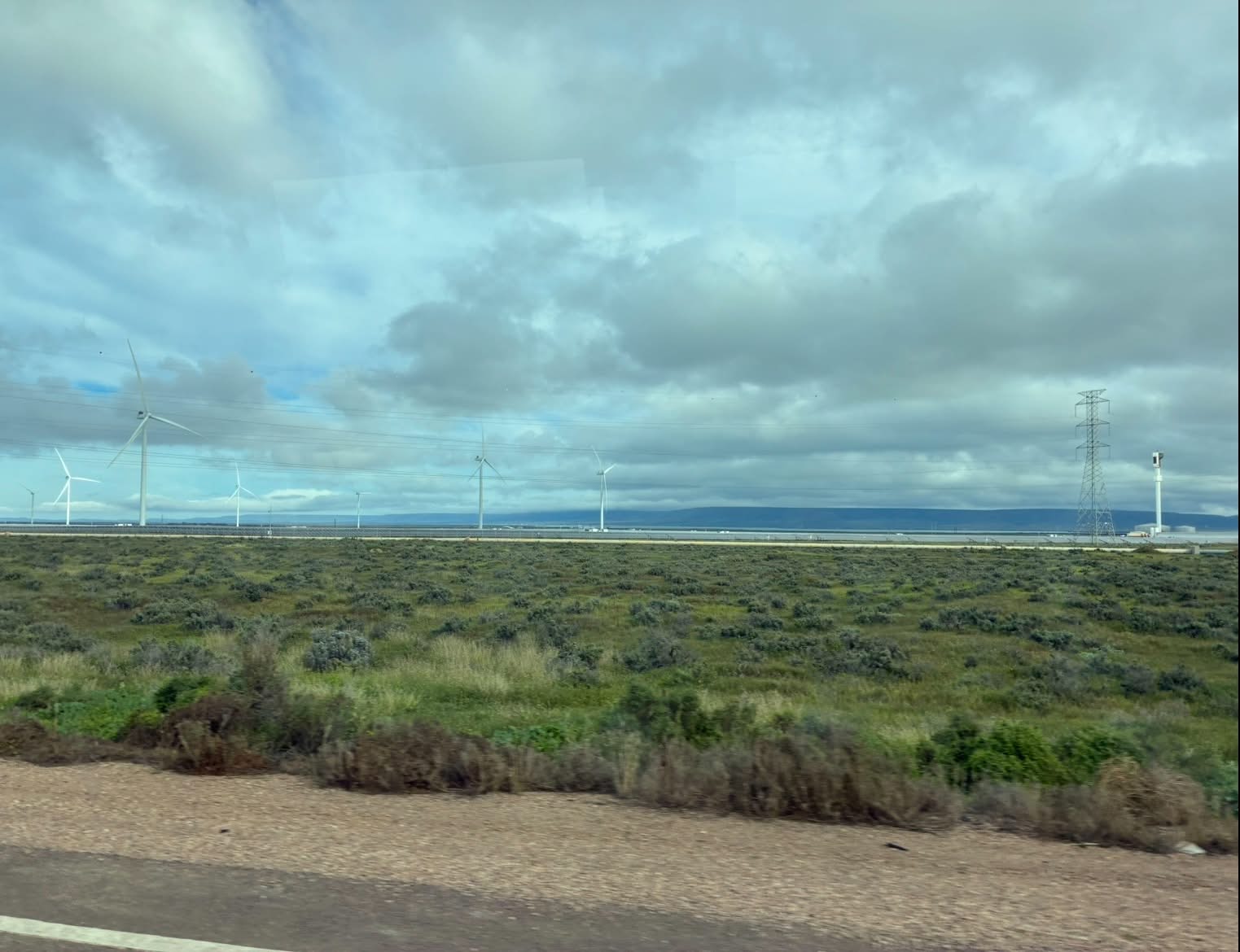 Wind turbines and power infrastructure beside the road during the Uluru expedition