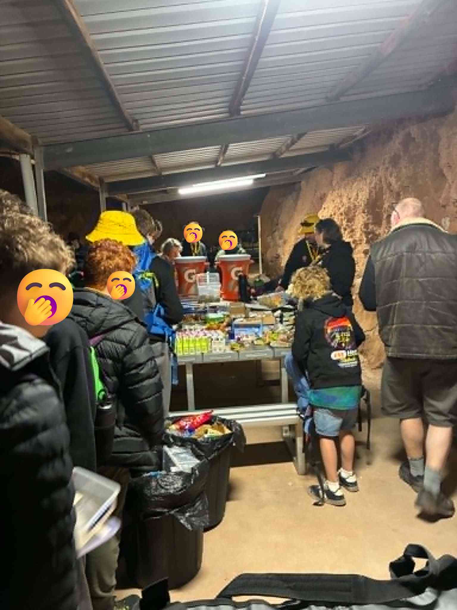 Uluru expedition group gathered around food supplies in an underground room at Coober Pedy