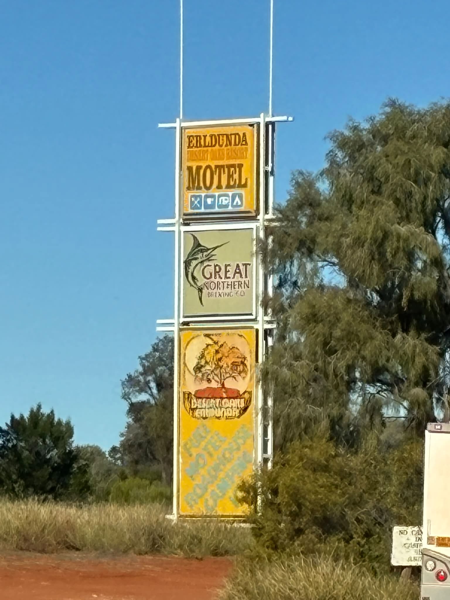 Erldunda Roadhouse motel sign beside red dirt on the Uluru expedition route