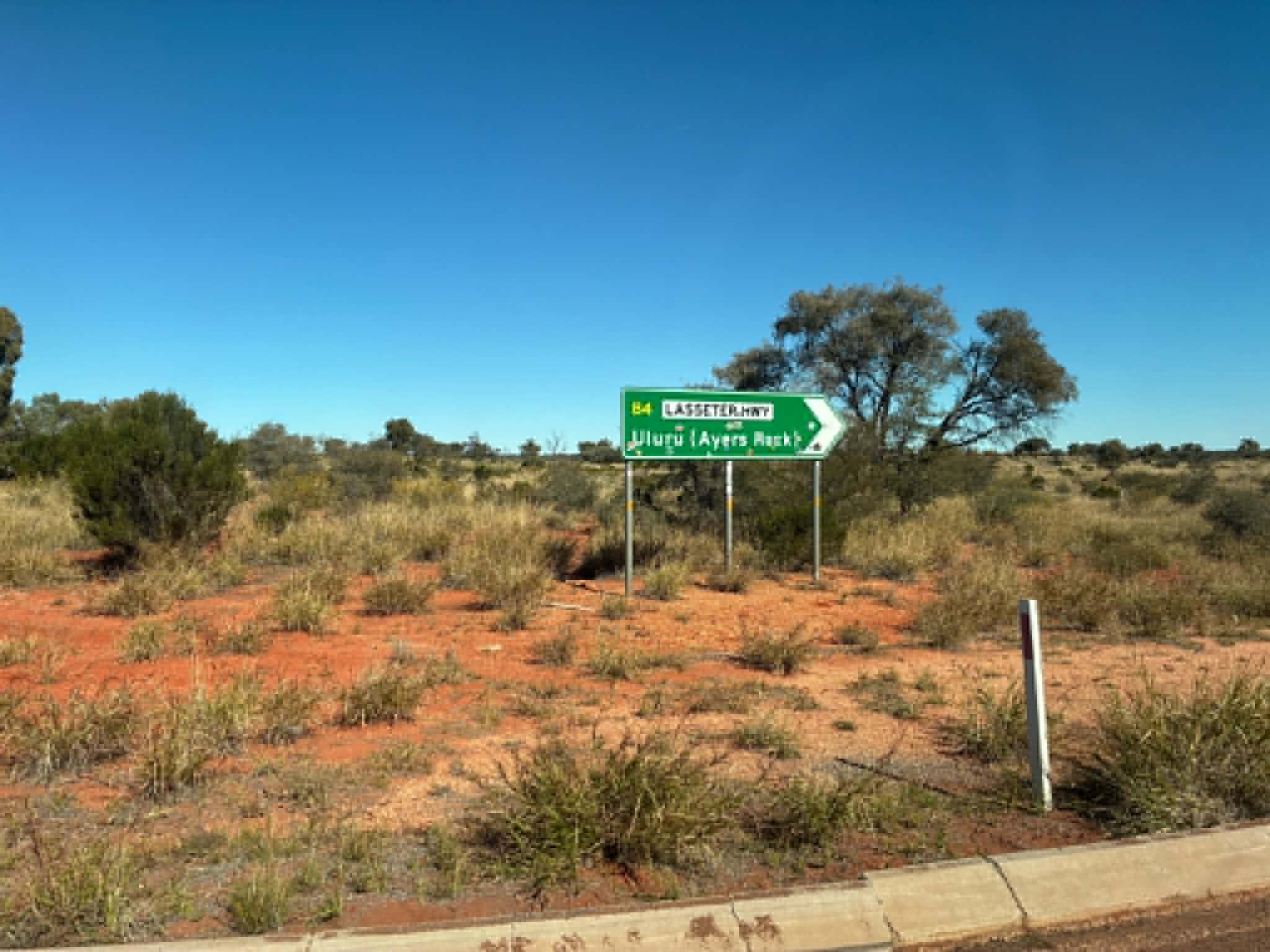 Lassetter Highway sign pointing towards Uluru and Ayers Rock