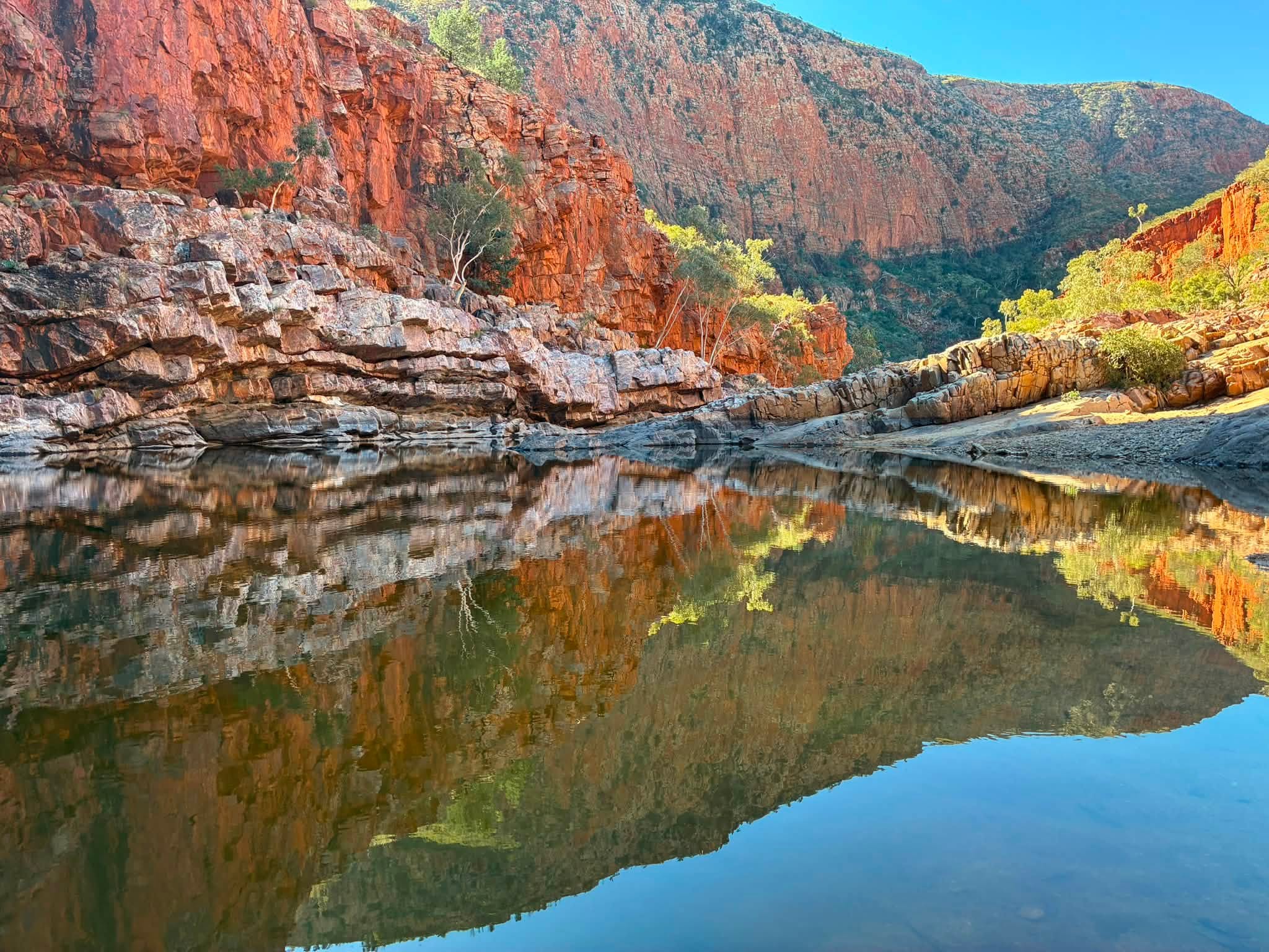 Red cliffs reflected in the water at Ormiston Gorge