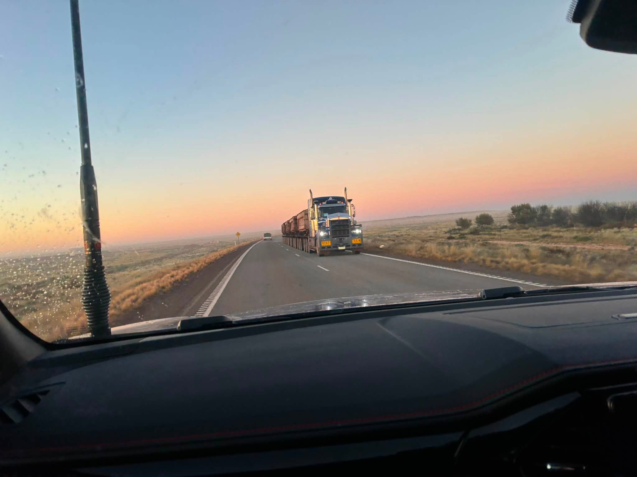 Road train passing the Uluru expedition convoy in the early morning light